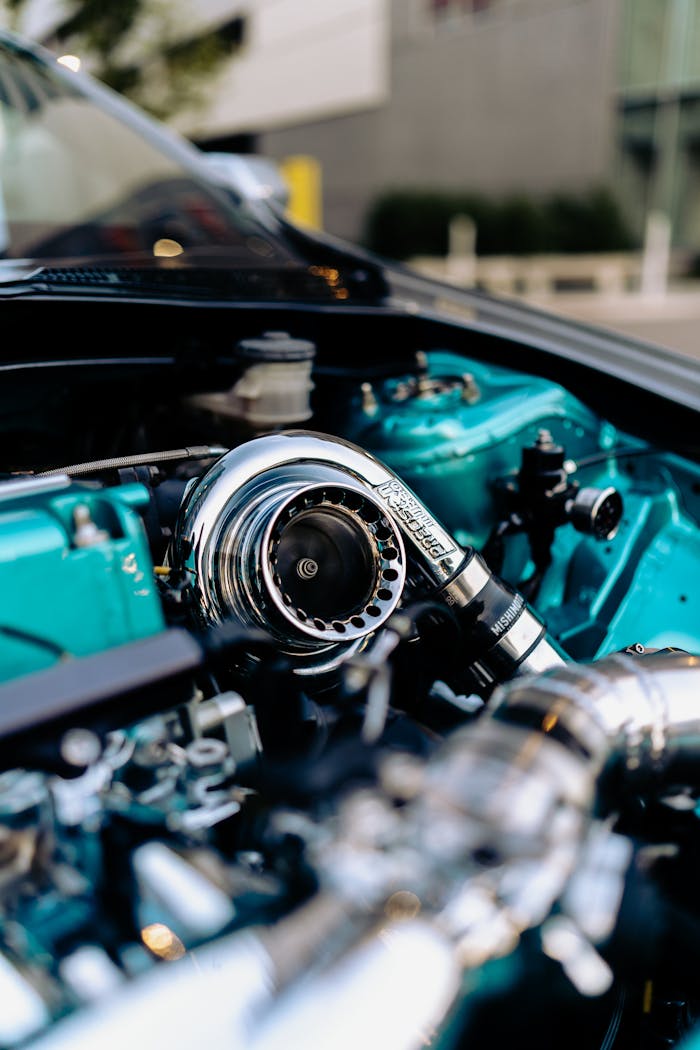 Detailed photo of a car turbocharger in a polished engine bay with chrome elements.