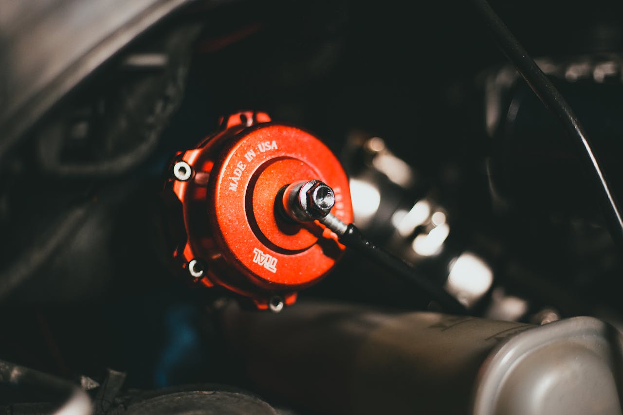 Detailed view of a red valve in a car engine, highlighting precision engineering.